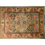 A Persian designed rug on a pale green/cream ground,