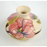 MOORCROFT; a cream ground squat baluster vase decorated in 'Magnolia' pattern,