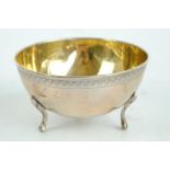 An 800 grade silver gilt bowl with banded engraved detail to the exterior rim and raised on three