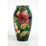 MOORCROFT; a 'Hibiscus' pattern tube line decorated ovoid vase on green ground,