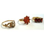 A 9ct gold dress ring set with three red stones, size M, a 9ct gold dress ring,