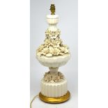 A cream ware table lamp with relief flower decoration on gold stand, height 66cm.