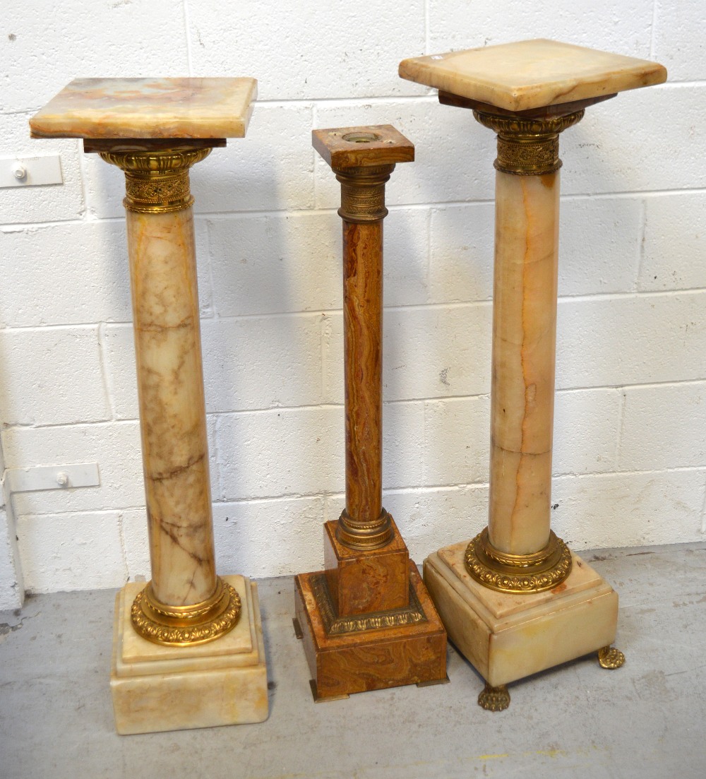 A pair of onyx ormolu-mounted column plinths and a further smaller marble example,