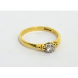 An 18ct yellow gold solitaire brilliant-cut diamond ring, decorative setting and shoulders, size K,