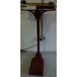 A vintage cast iron floor-standing weighing scale with brass measures to top, height 123cm.