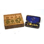 A mahogany-cased set of brass weights and a cased set of optical instruments and weights with