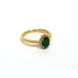 A 9ct yellow gold oval emerald (approx 0.75ct) and diamond cluster ring, size N, approx 2.6g.