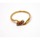 An 18ct gold ring set with small central ruby and tiny diamond to either side, size T, approx 2.85g.