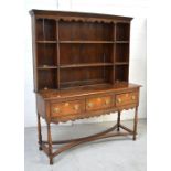 An early 19th century oak dresser, the boarded plate rack above three frieze drawers,