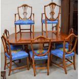 A dining suite comprising a reproduction table and chairs with Hepplewhite backs and seats