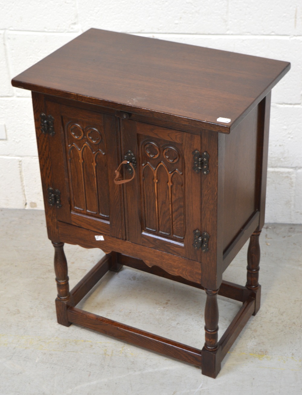 A small carved oak cupboard on legs, two doors, height 68cm.