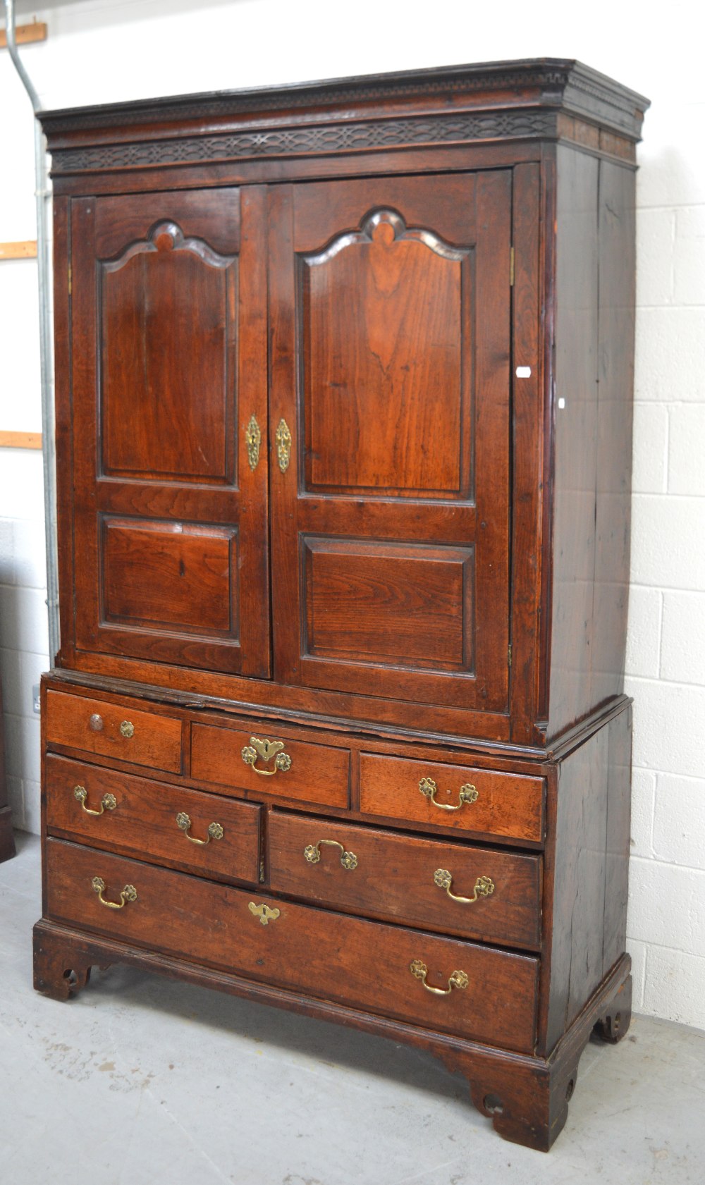 A George III oak livery cupboard with pair of panelled doors above six-drawer base on bracket feet,