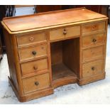 A Victorian pine kneehole desk with upstand, central drawer flanked by two banks of four drawers,