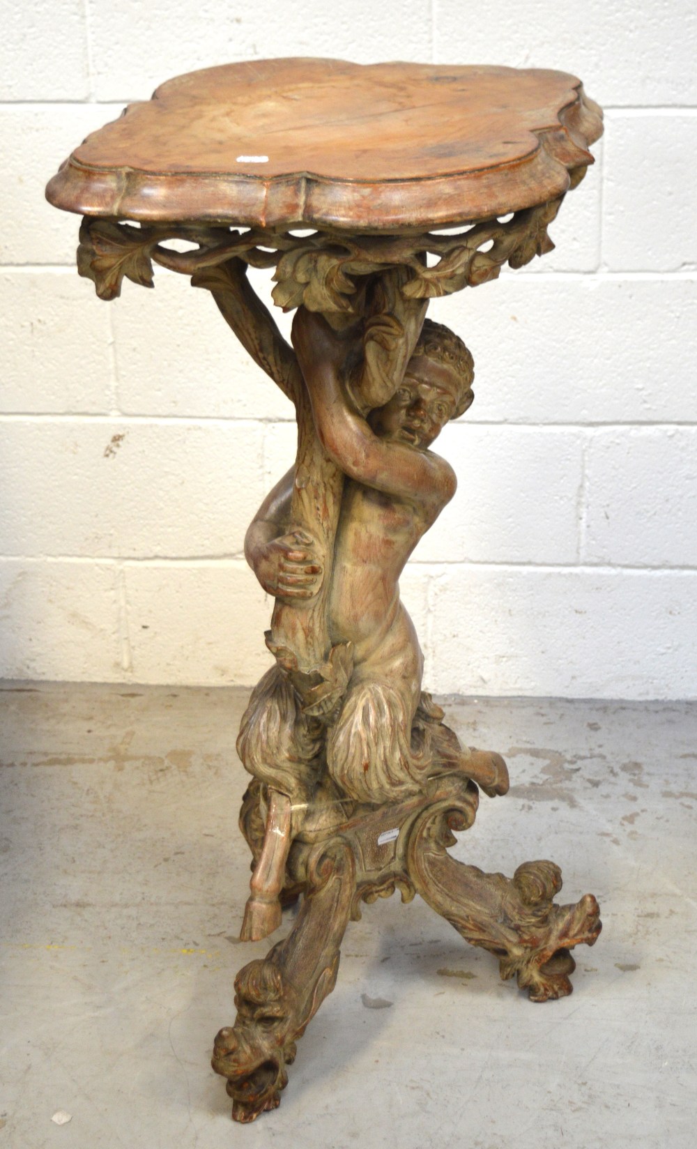 A heavily carved pine figural pedestal table,