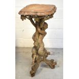 A heavily carved pine figural pedestal table,