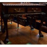 A mahogany carved occasional table with two short drawers on cabriole legs terminating in claw feet,