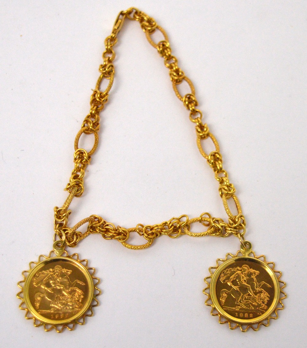 A 9ct gold link chain bracelet suspending two half sovereigns, both Queen Elizabeth II 1982,