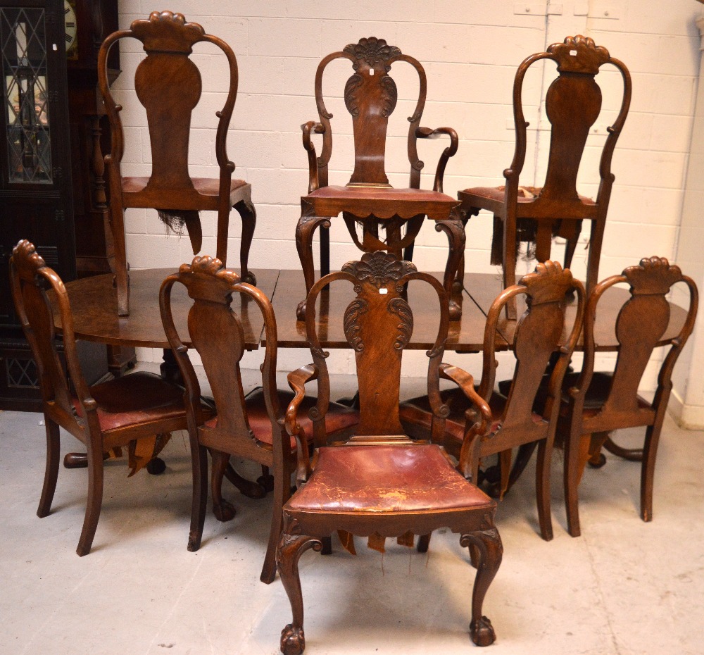 A large Edwardian walnut dining table on three baluster supports,