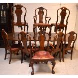 A large Edwardian walnut dining table on three baluster supports,