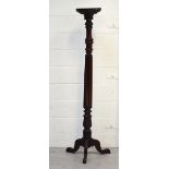 A late 19th early 20th century mahogany torchère with turned column to outswept tripod legs,