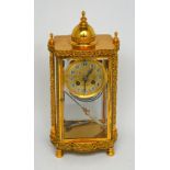 A brass-cased eight-day chiming mantel clock with bevelled glass casement, mercury pendulum,