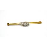 A platinum and yellow gold brilliant-set three-diamond crossover bar brooch,