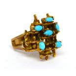 A yellow metal ladies' dress ring of abstract design, set with six turquoise-coloured stones,