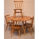 A 1960s Ercol light elm oval drop-leaf dining table,