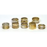 Eight hallmarked silver napkin rings to include a George V hexagonal plain example with 'DS'