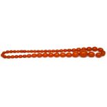 A c1920s butterscotch amber-coloured bead necklace of 47 beads, length 66cm,