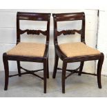 A pair of Georgian mahogany dining chairs with carved back splat on sabre legs to turned