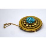 A Victorian yellow metal circular mourning brooch with small turquoise set to centre and leaf