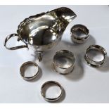 A George V hallmarked silver sauceboat, Sheffield 1934 and five hallmarked silver napkin rings,