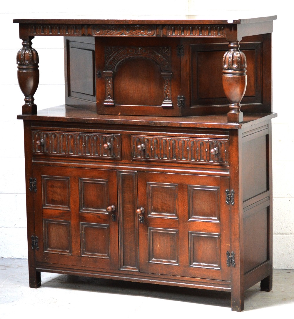 A 20th century carved oak court cupboard, single central cupboard door over two short drawers,