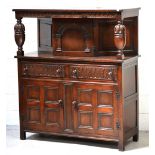 A 20th century carved oak court cupboard, single central cupboard door over two short drawers,