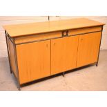 A contemporary sideboard, three cupboard doors with one interior shelf with metal trim,