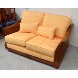 A large hardwood Multiyork bergère-style sofa with yellow damask loose cover, length 150cm.