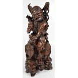 A large circa 1900 Chinese carved rootwood figure of an immortal holding a peach,