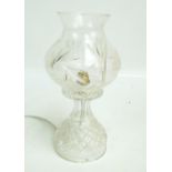 A clear cut glass table lamp with tulip shaped shade above spreading circular base, height 32cm.