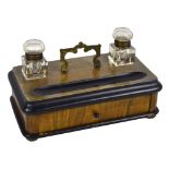 A Victorian walnut inkstand with rounded corners, two square glass inkwells with hinged lids,