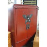 A Chinese red lacquered two door cabinet with stylised butterfly metalwork applied decoration and