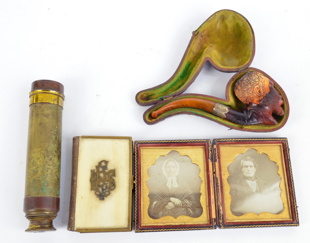 A cased Meerschaum pipe decorated as a black man's head with amber coloured mouthpiece and silver