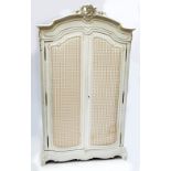 A 19th century French painted armoire with shaped scrolling cornice above two full length doors