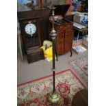 A late 19th century brass standard lamp with fluted central column and three paw feet.