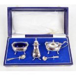 A cased Elizabeth II hallmarked silver three piece set, comprising an oval open salt with cast rim,