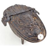 A cast iron coal scuttle decorated with floral and foliate scrolls and with mask to the hinged lid