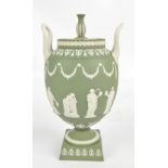 WEDGWOOD; a green jasperware ovoid vase and cover with high loop handles,