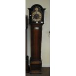 An early 20th century grandmother clock with arched brass dial and Roman numerals to the silver