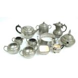 A small group of hammered pewter including a teapot, a hot water jug and cream jugs,