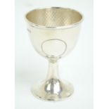 ATKIN BROS; an Edward VII hallmarked silver Arts and Crafts hammered egg cup on tapering foot,